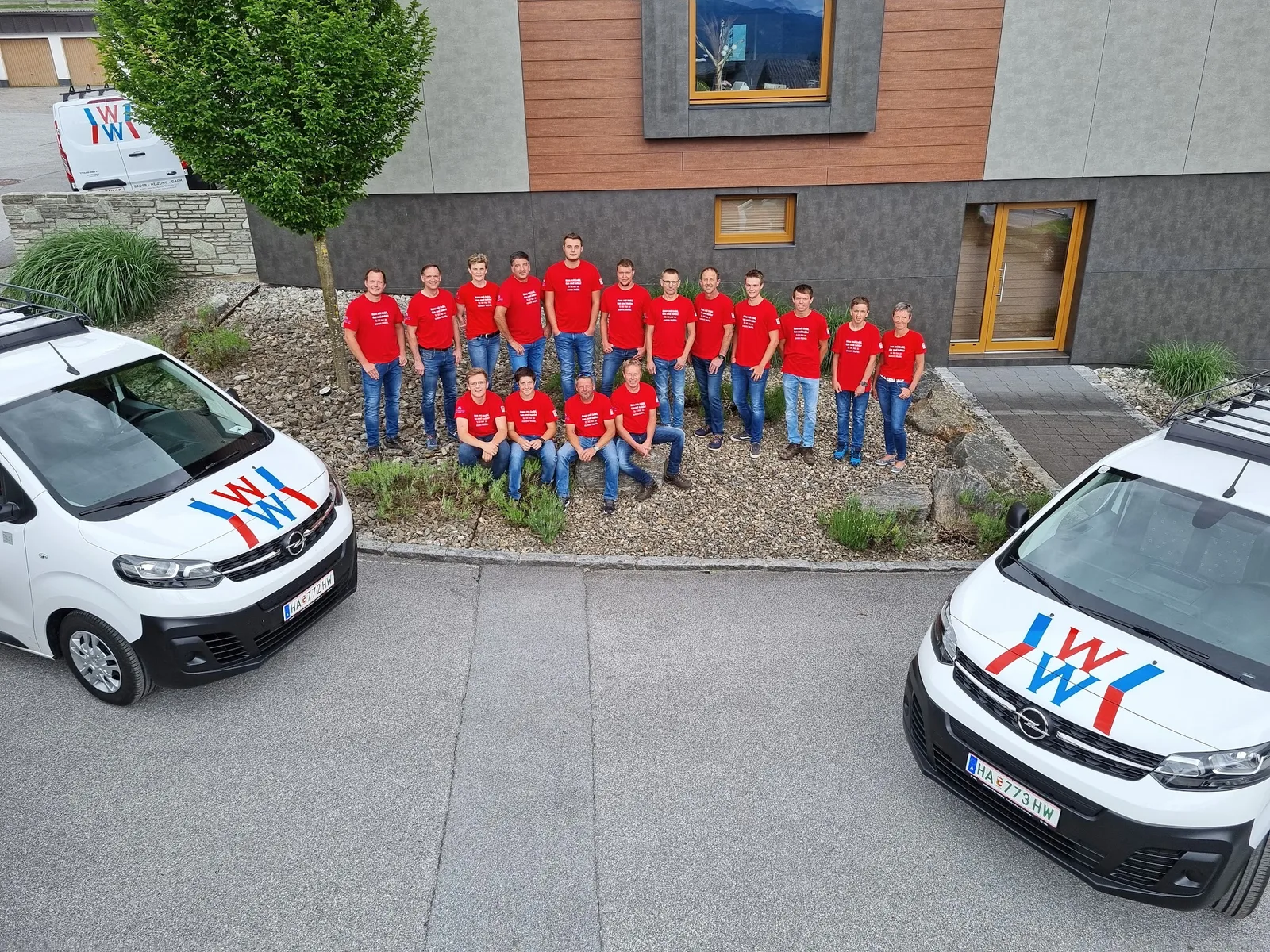 Windhofer Team vor beschrifteten Firmenfahrzeugen