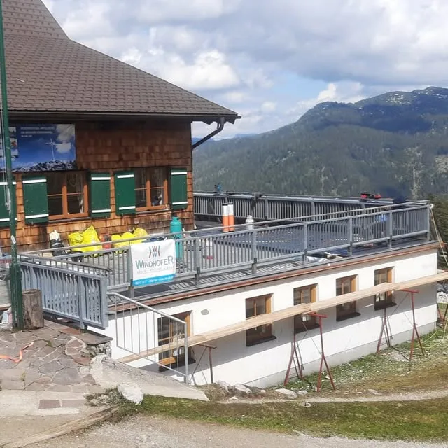 Baustelle an einem Berggebäude mit Windhofer Banner